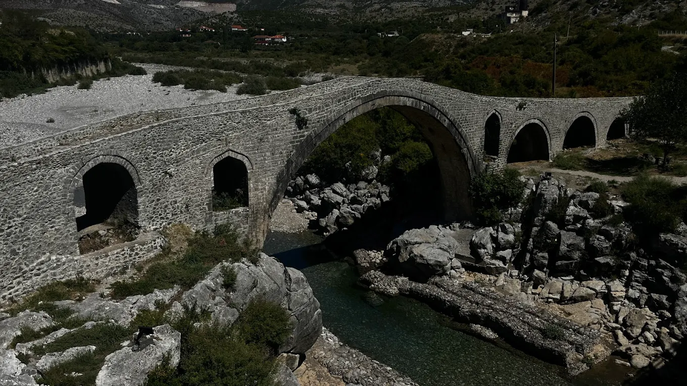 Old stone bridge crossing a river surrounded by nature